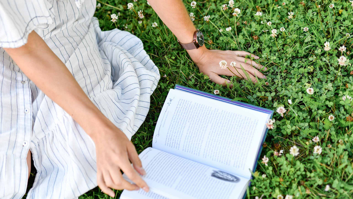 woman-reading-book-on-green-grass-with-rohje-adventurister-antarctica-watch